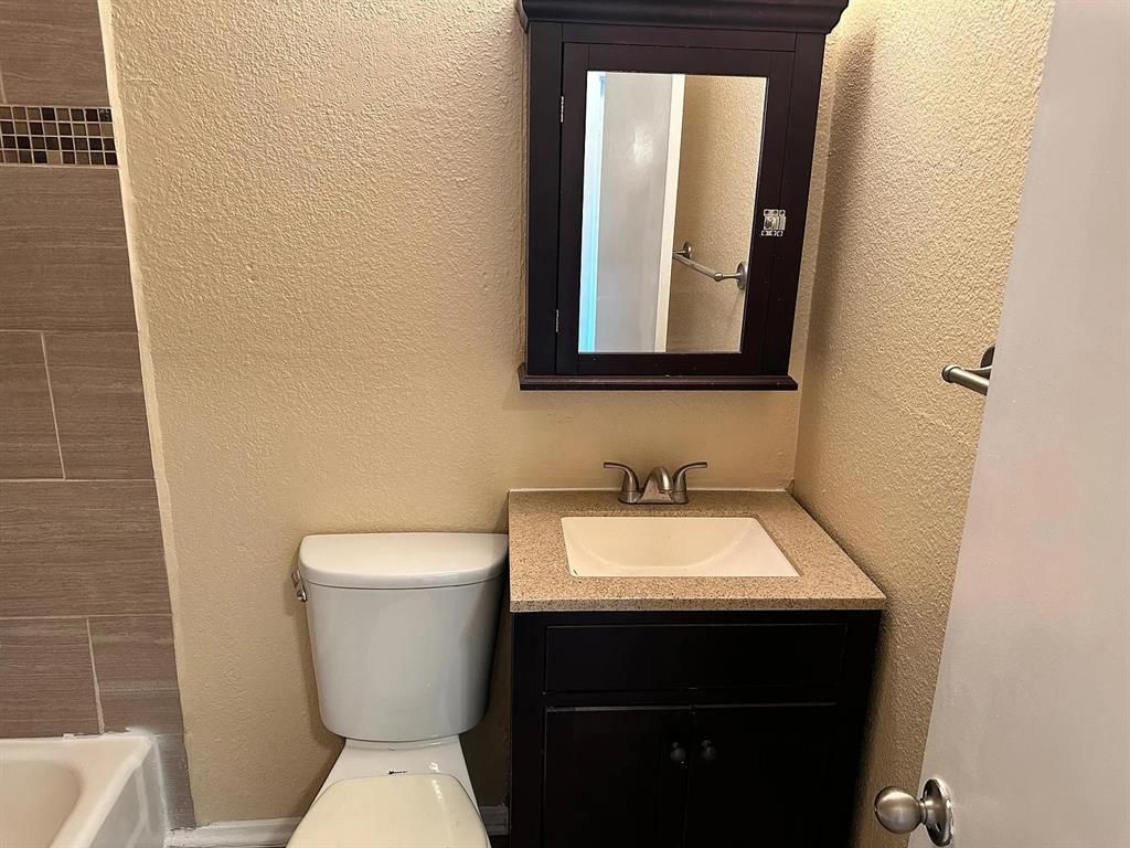 2401 Manor Road, Unit 220 Austin, TX 78722 - Photo 1 of 17 Granite counters and textured walls define this compact powder room layout.