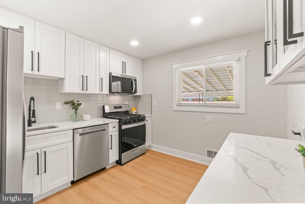 3500 Edwards Street Lanham, MD 20706 - Photo 14 of 40 a kitchen with stainless steel appliances granite countertop a sink stove and refrigerator