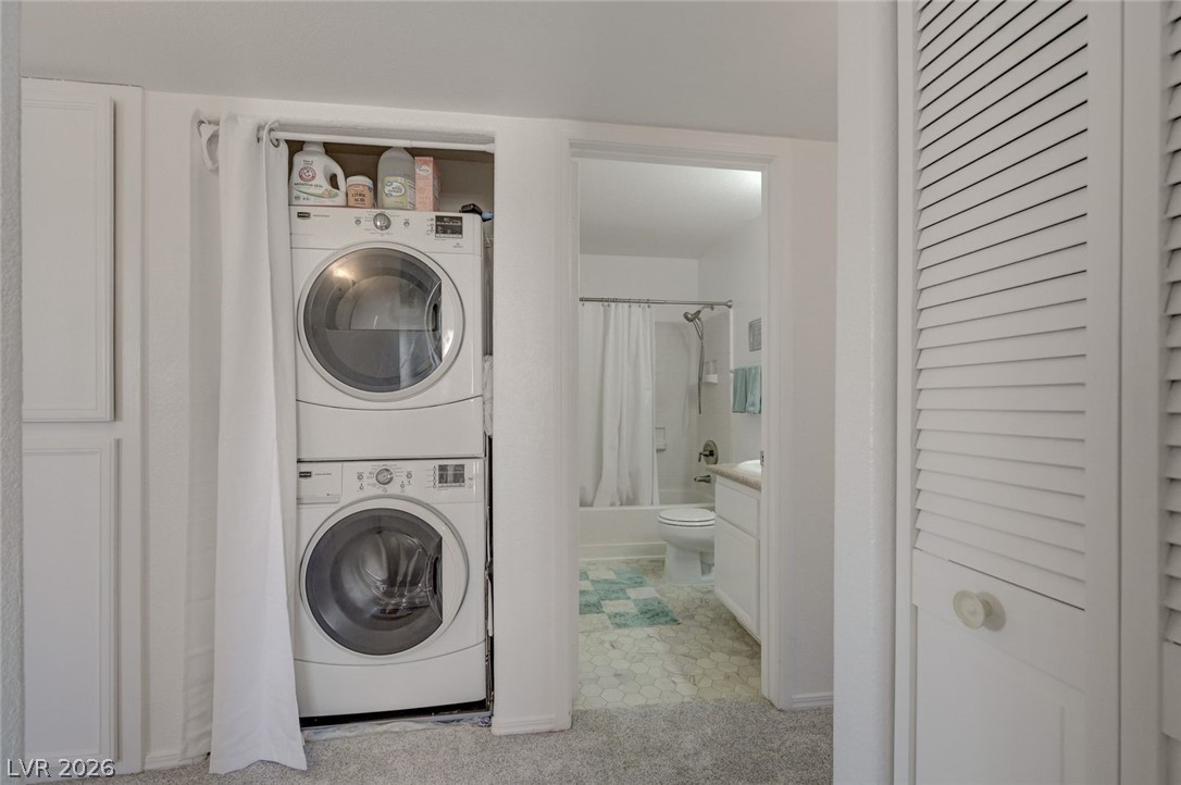 3318 North Decatur Boulevard, Unit 2072 Las Vegas, NV 89130 - Photo 28 of 50 Stacked laundry appliances offer convenient utility access, adjacent to a well-appointed bathroom.