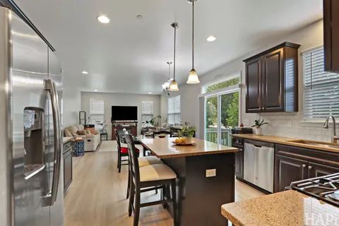a kitchen with a sink stainless steel appliances and dining table