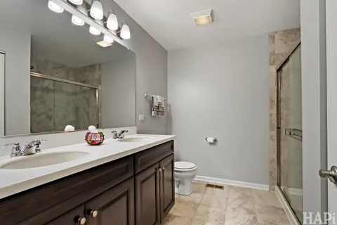 a spacious bathroom with a granite countertop sink a toilet and a mirror