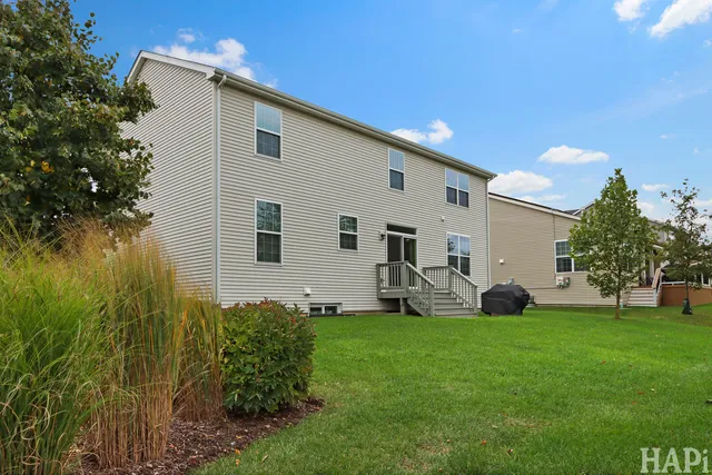 a front view of a house with a yard and tree
