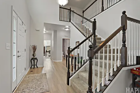 a view of staircase with wooden floor and a chandelier