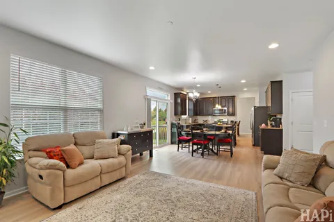 a living room with furniture kitchen and a large window