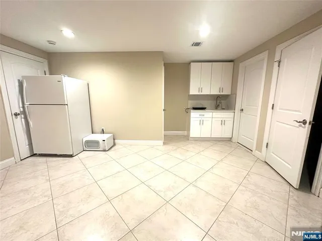 a kitchen with a refrigerator a stove a microwave and white cabinets