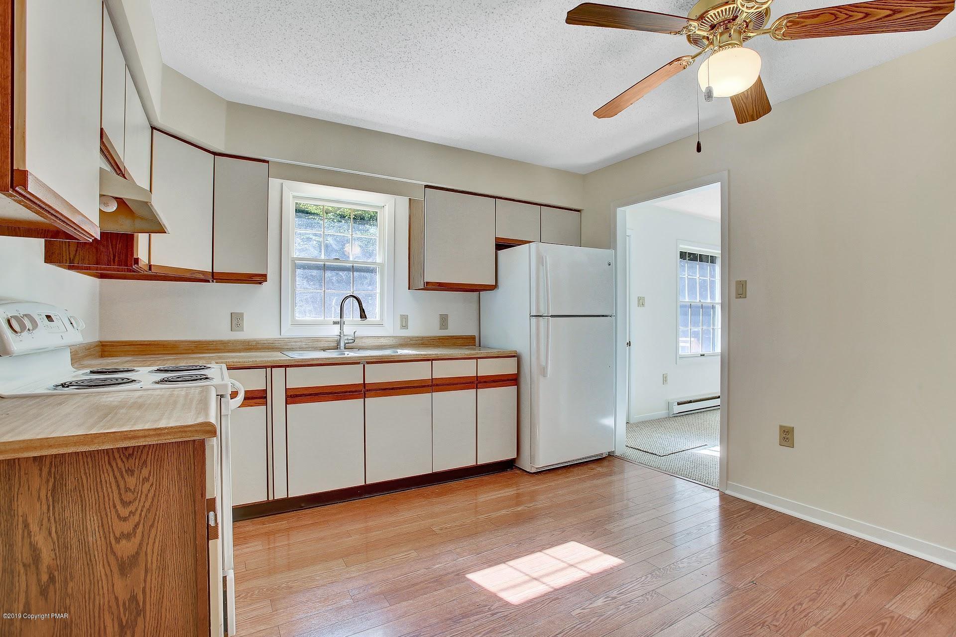 295 Sundance Road Effort, PA 18330 - Photo 8 of 25 a kitchen with stainless steel appliances granite countertop a refrigerator a sink dishwasher a stove and a dining table with wooden floor