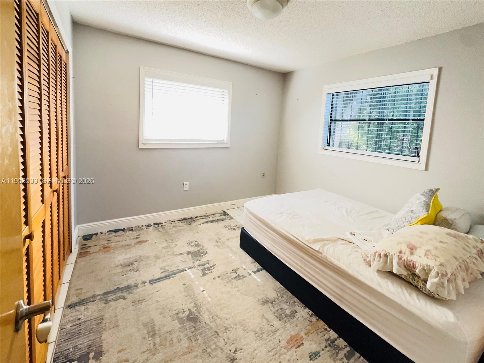 11510 Southwest 191st Terrace Miami, FL 33157 - Photo 10 of 15 a bedroom with a bed and a window