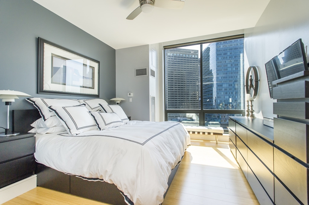 45 Province Street, Unit 1903 Boston, MA 02108 - Photo 6 of 31 a bedroom with a large bed and a flat tv screen on dresser