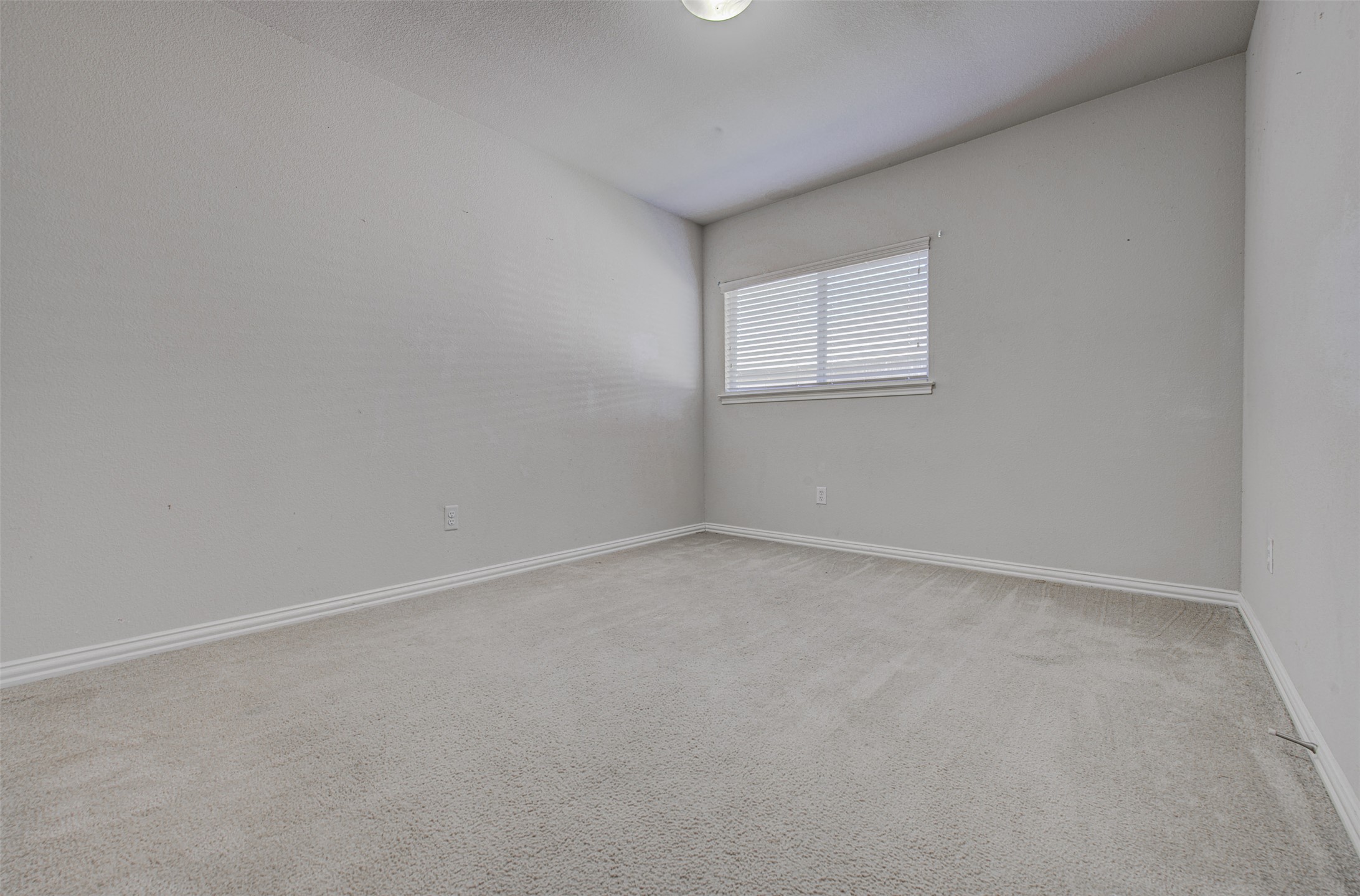 2090 Intrepid Drive Buda, TX 78610 - Photo 16 of 24 Empty room featuring light carpet and baseboards