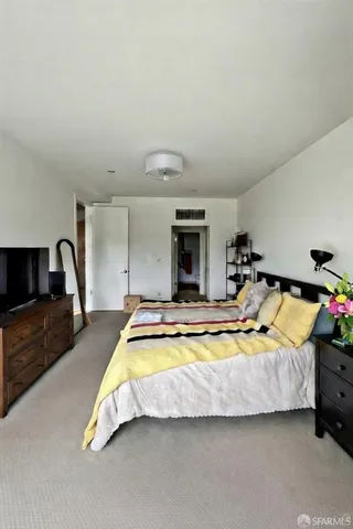 a spacious bedroom with a bed and a flat screen tv