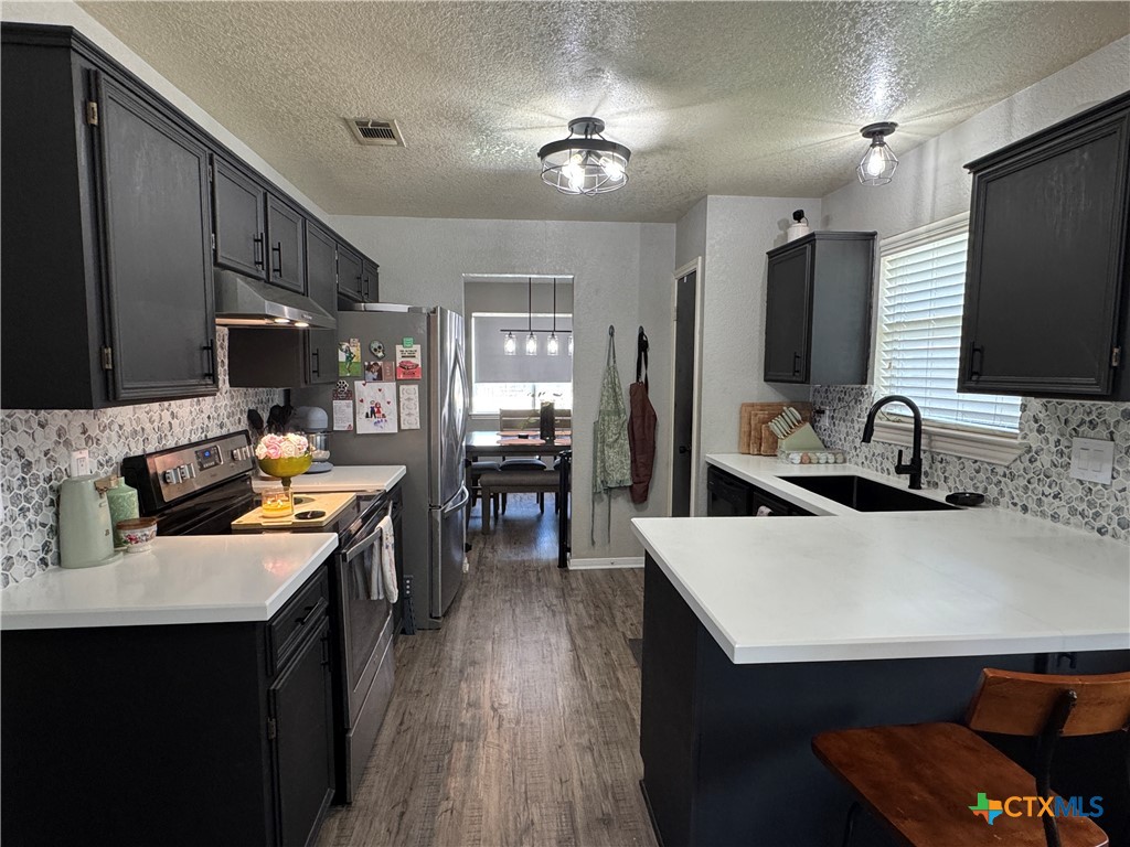 1817 Dusk Drive Killeen, TX 76543 - Photo 2 of 23 a kitchen with a sink a stove and chairs