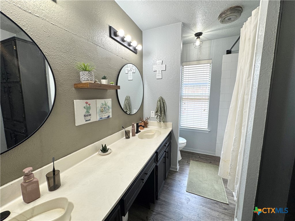 1817 Dusk Drive Killeen, TX 76543 - Photo 22 of 23 a en suite bathroom with a double vanity sink and a mirror