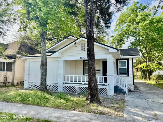 a front view of a house with a tree