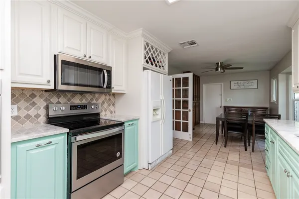 a kitchen with granite countertop a stove and a microwave oven