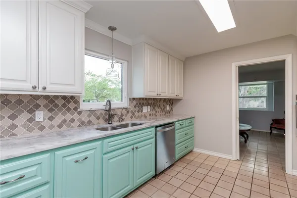a kitchen with a sink window and cabinets