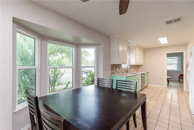 a view of kitchen with sink dining table and chairs