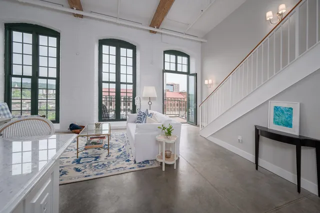 a living room with furniture and large windows