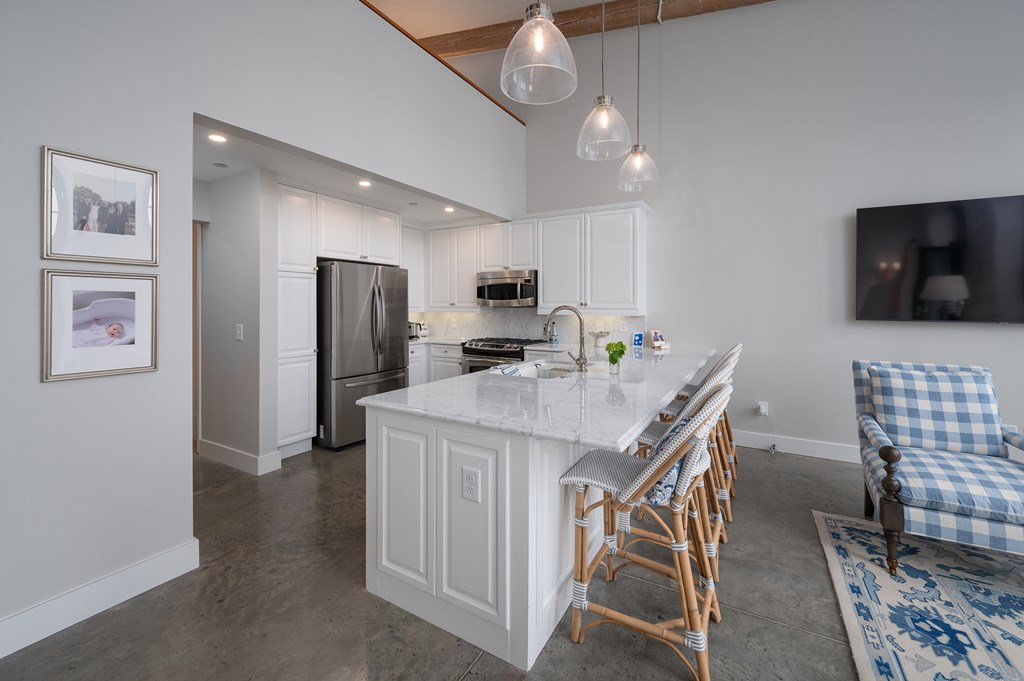 1201 Front Avenue, Unit 507 Columbus, GA 31901 - Photo 16 of 46 a kitchen with stainless steel appliances kitchen island granite countertop a refrigerator and microwave