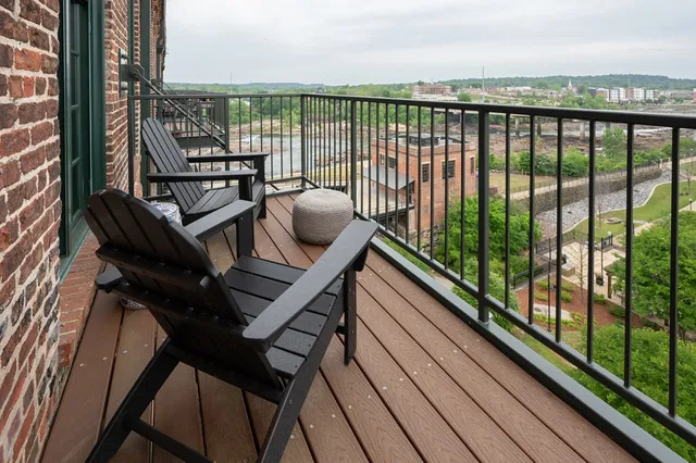 a view of a balcony with wooden floor and outdoor seating