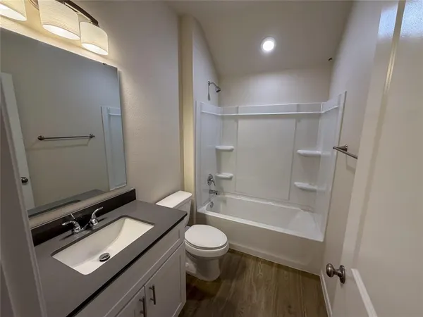 a bathroom with a granite countertop sink toilet a mirror and shower