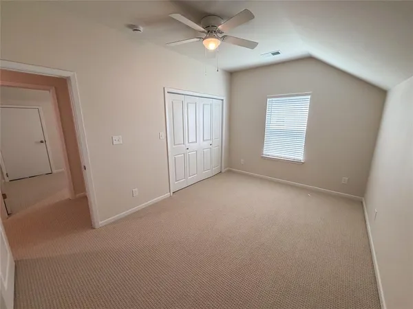 an empty room with a ceiling fan and a window