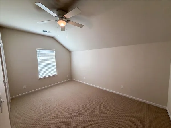 an empty room with a window and a ceiling fan