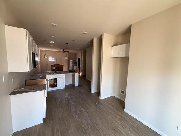 a living room with stainless steel appliances kitchen island furniture and wooden floor