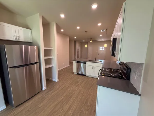 a kitchen with stainless steel appliances a refrigerator a stove a sink and a oven