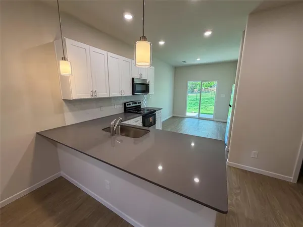 a kitchen with a sink a window stainless steel appliances and cabinets