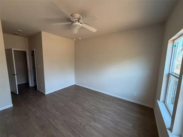 an empty room with wooden floor and a window