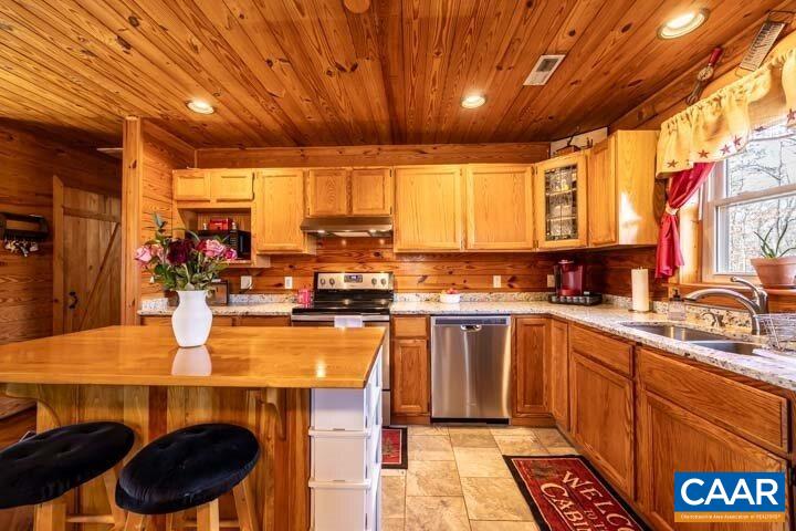 5880 Mechunk Ridge Lane Keswick, VA 22947 - Photo 17 of 38 a kitchen with stainless steel appliances a stove a sink dishwasher and cabinets with wooden floor