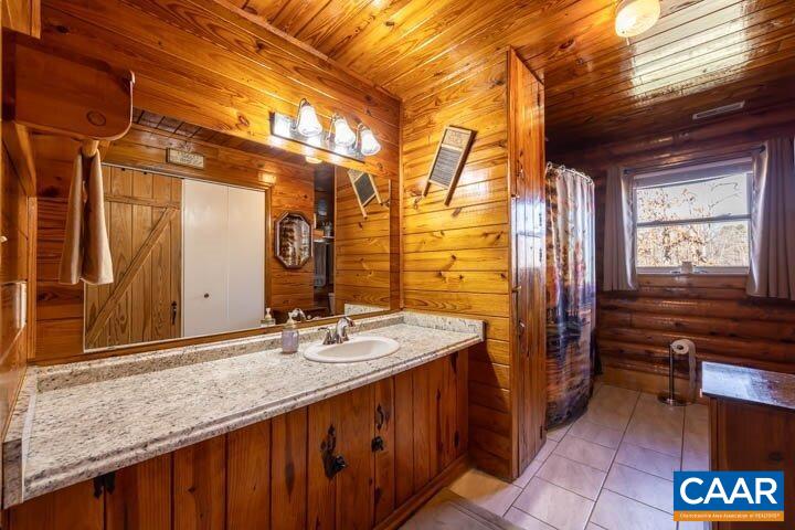 5880 Mechunk Ridge Lane Keswick, VA 22947 - Photo 29 of 38 a bathroom with a granite countertop sink and a mirror