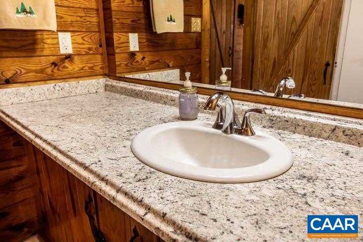 5880 Mechunk Ridge Lane Keswick, VA 22947 - Photo 32 of 38 a bathroom with a granite countertop sink and a mirror