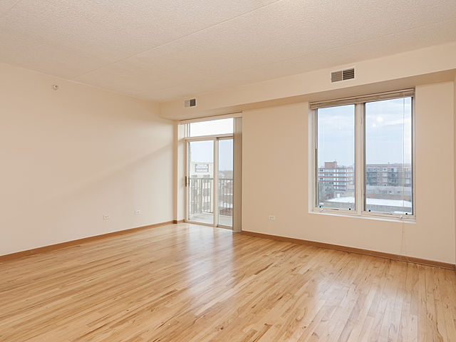 515 Main Street, Unit 707 Evanston, IL 60202 - Photo 4 of 12 an empty room with wooden floor and windows