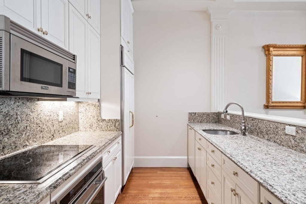 226 Commonwealth Avenue, Unit 1 Boston, MA 02116 - Photo 6 of 17 a kitchen with granite countertop stainless steel appliances a stove sink and microwave