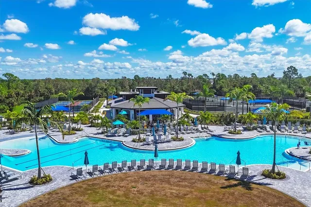 a view of a swimming pool with lawn chairs and a potted plants