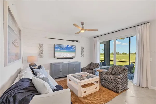 a living room with furniture and a view of kitchen