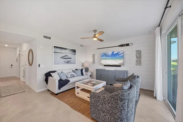 a kitchen with stainless steel appliances a stove a sink a refrigerator white cabinets and chairs