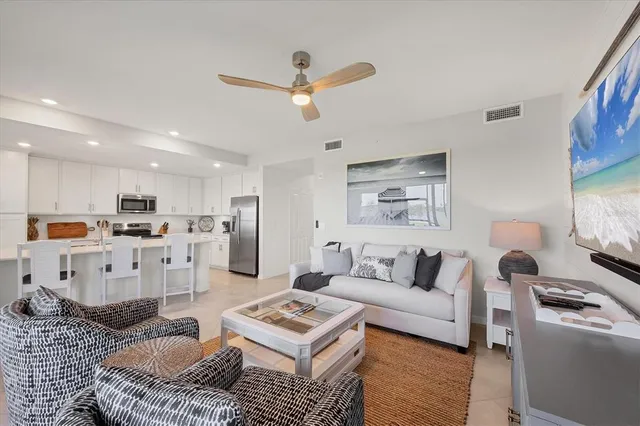 a kitchen with stainless steel appliances granite countertop a refrigerator a stove a sink a dining table and chairs