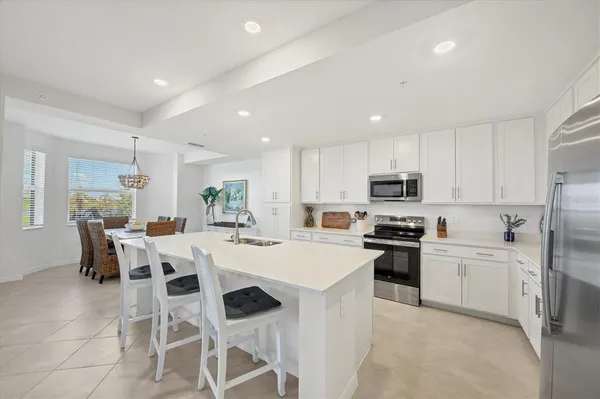 a large white kitchen with stainless steel appliances