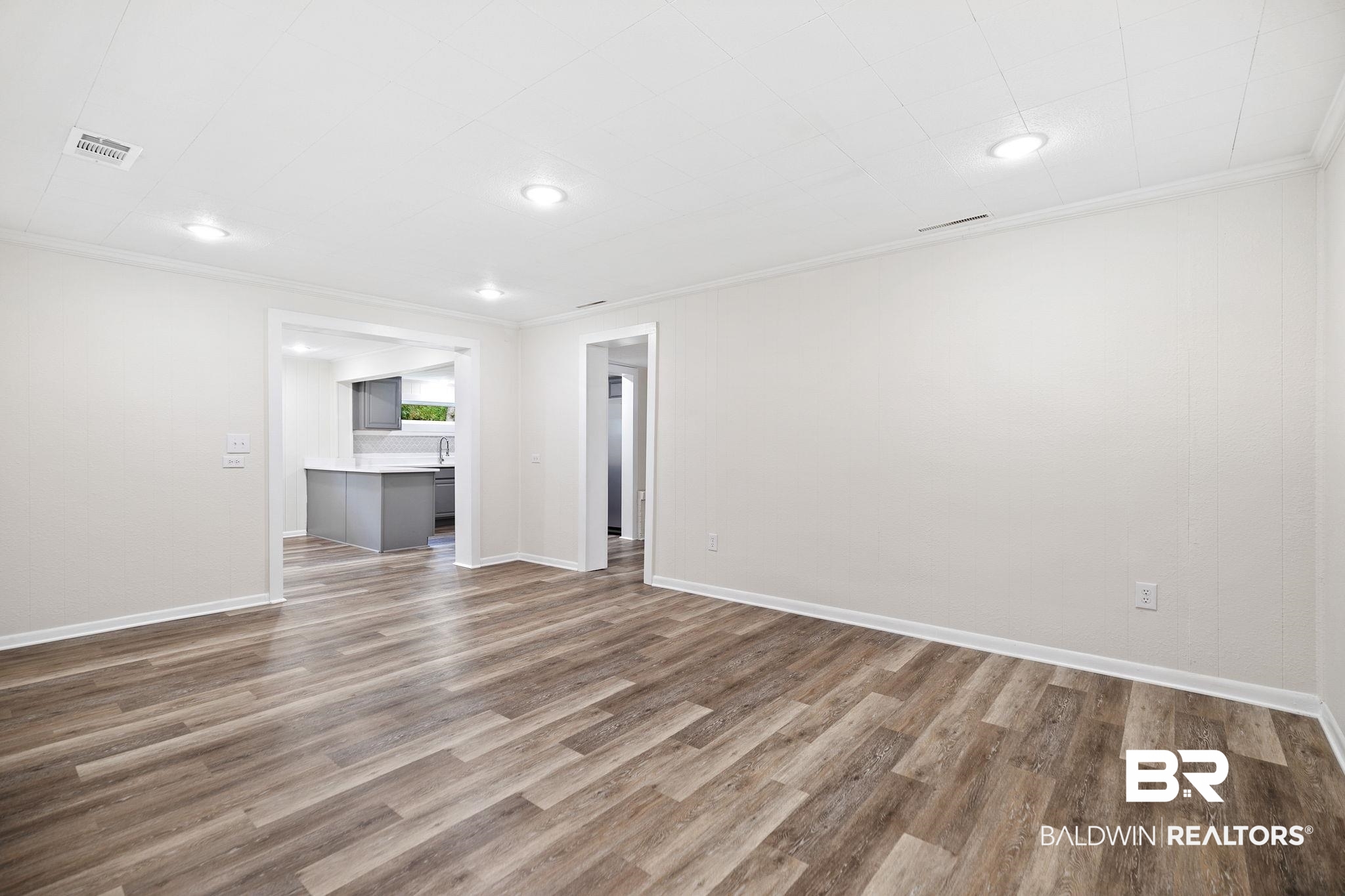 507 Byrne Street Bay Minette, AL 36507 - Photo 21 of 40 Unfurnished living room with wood-type flooring and crown molding