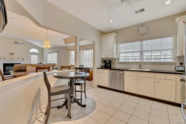 a kitchen with stainless steel appliances granite countertop a table chairs sink and cabinets