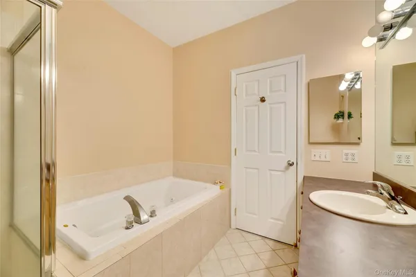 a bathroom with a tub sink and mirror