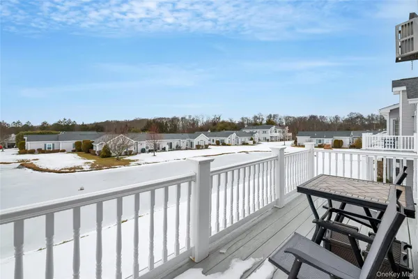 a view of a balcony with wooden chairs and city view