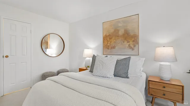 a bedroom with a bed and a lamp on dresser