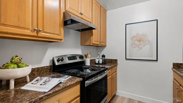 a kitchen with stainless steel appliances granite countertop a stove a sink and a microwave