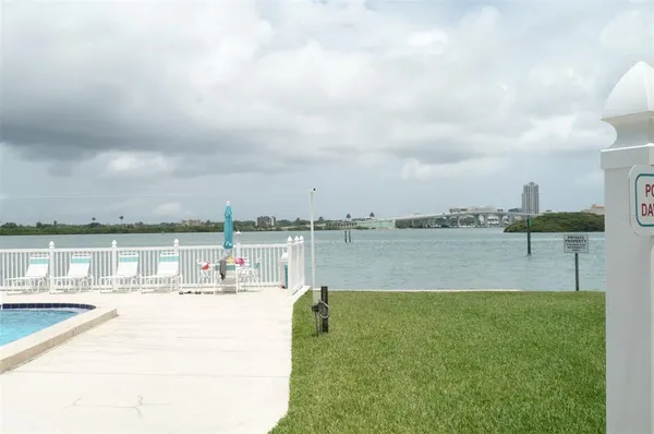 a view of a lake with a big yard and large trees