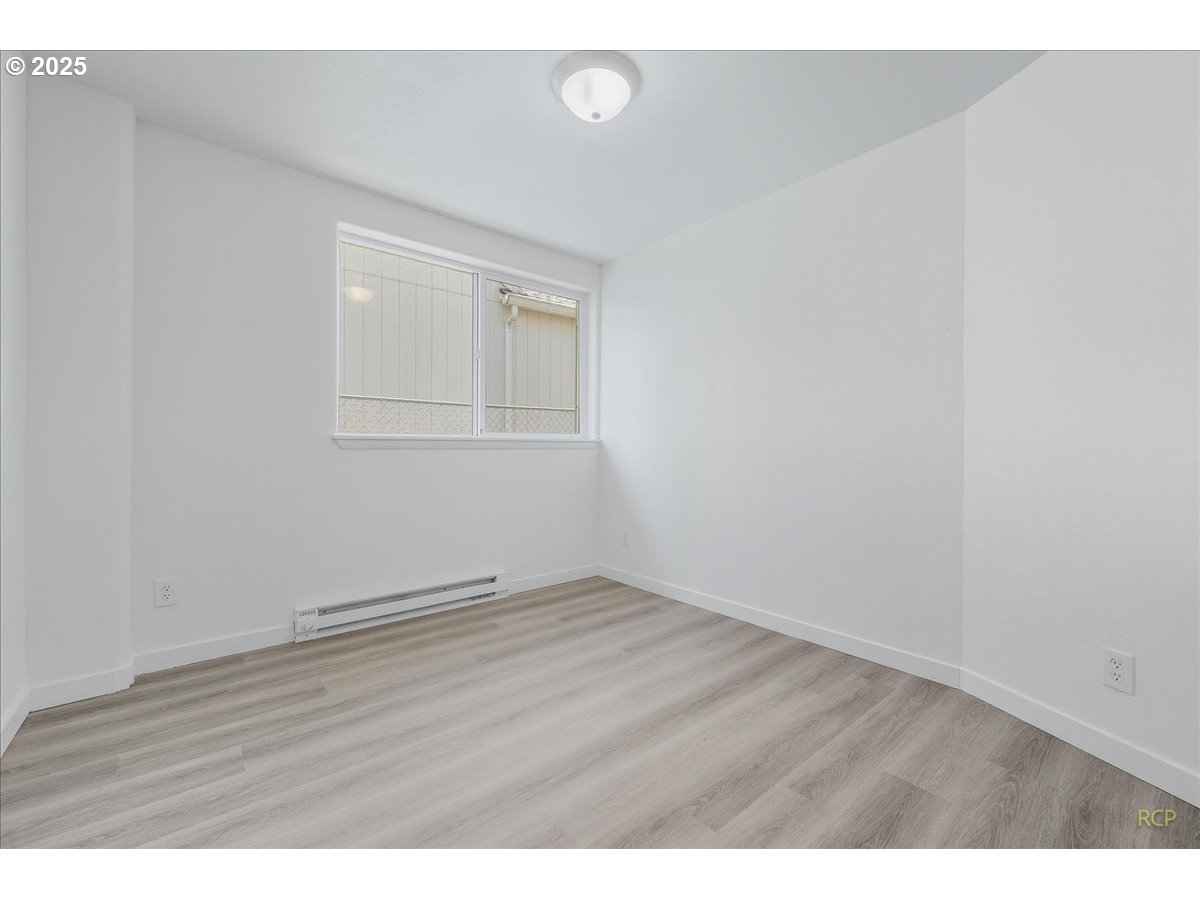 11420 Southeast Clinton Street Portland, OR 97266 - Photo 16 of 34 a view of an empty room with wooden floor and a window