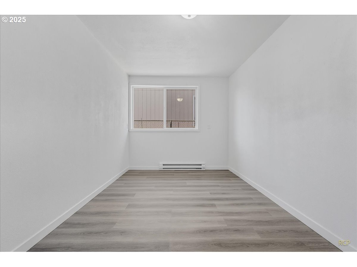 11420 Southeast Clinton Street Portland, OR 97266 - Photo 19 of 34 a view of an empty room with wooden floor and a window