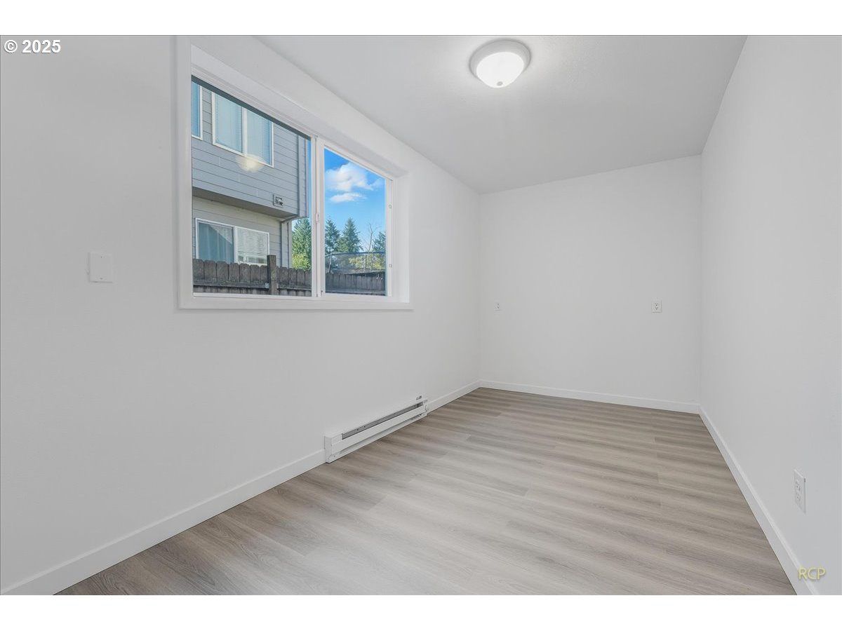 11420 Southeast Clinton Street Portland, OR 97266 - Photo 20 of 34 a view of an empty room with wooden floor and a window